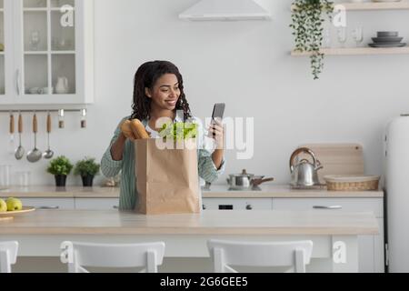 Femme tenant un sac de papier plein d'aliments et de légumes frais et sains Banque D'Images