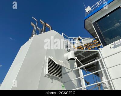 Tuyaux d'échappement brillants sortant de l'entonnoir blanc d'UN nouveau bateau de service de ferme de pêche Banque D'Images