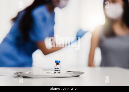 Les vaccins COVID-19 sur la table, la pandémie de coronavirus et les vaccins sauvent des millions de vies concept avec le médecin injecte les gens de fond Banque D'Images