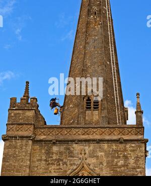 Steeplejack travaillant sur le Spire de l'église Saint-Jean-Baptiste, Burford, Oxfordshire Banque D'Images