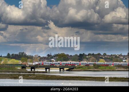 Train de passagers de classe 745 dans la grande décoration d'Anglia traversant le viaduc de Manningtree, de l'autre côté de la rivière Stour, Essex, Angleterre. Banque D'Images