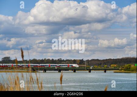 Train de passagers de classe 745 dans la grande décoration d'Anglia traversant le viaduc de Manningtree, de l'autre côté de la rivière Stour, Essex, Angleterre. Banque D'Images