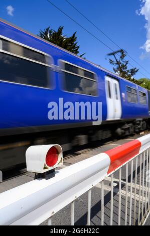 Train traversant un passage à niveau à grande vitesse dans l'Essex, en Angleterre. Banque D'Images