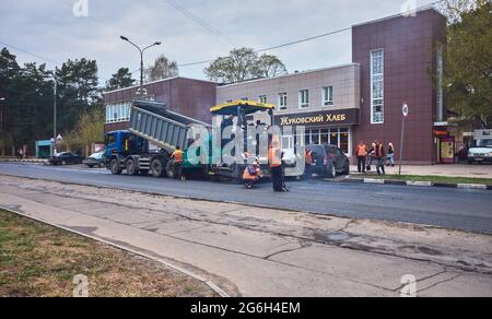 Les travailleurs de la route posent de l'asphalte neuf dans une rue de la ville: Zhukovsky, Russie - 30 avril 2021 Banque D'Images