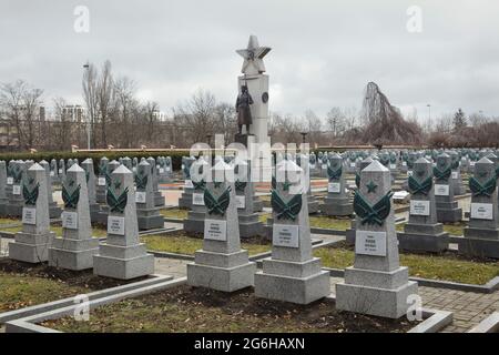 Mémorial de guerre soviétique au cimetière d'Olšany à Prague, République tchèque. Deux statues en bronze de soldats de l'armée rouge conçues par le sculpteur tchèque Jaroslav Brůha (1945) sont installées sur le pilier en pierre conçu par l'architecte tchèque Karel Beneš entouré de tombes de solders soviétiques tombés dans les derniers jours de la Seconde Guerre mondiale et morts après la guerre. Des tombes de solders soviétiques sont photographiées après les travaux de restauration, qui ont eu lieu de l'été 2020 au printemps 2021. Banque D'Images