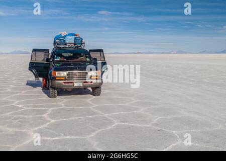 SALAR DE UYUNI, BOLIVIE - 17 AVRIL 2015 : 4X4 avec des touristes au plat salin de Salar de Uyuni, Bolivie Banque D'Images