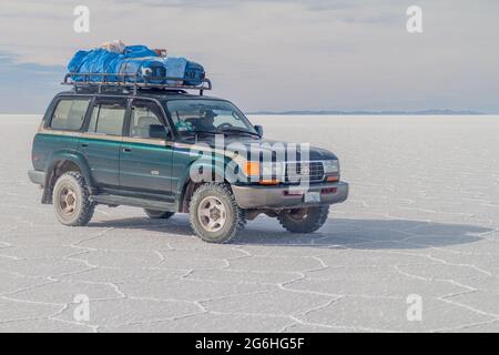 SALAR DE UYUNI, BOLIVIE - 17 AVRIL 2015 : 4X4 avec des touristes au plat salin de Salar de Uyuni, Bolivie Banque D'Images