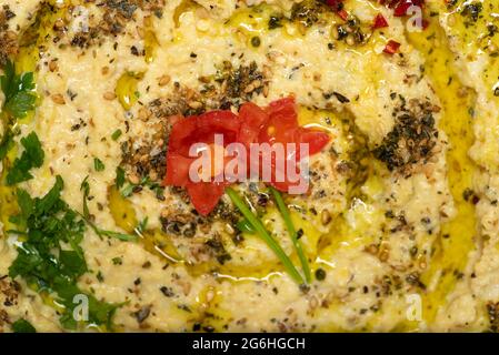 Sauce hummus à base de pois chiches, de sésame et d'autres ingrédients, utilisée traditionnellement dans les cuisines méditerranéenne et moyenne-Pâques, servie dans un bol Banque D'Images