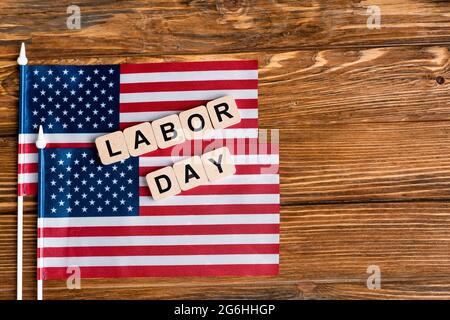 vue de dessus des petits drapeaux et cubes des états-unis avec inscription de la fête du travail sur une table en bois Banque D'Images