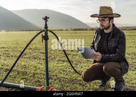 Photo d'un homme utilisant une technologie d'irrigation intelligente Banque D'Images