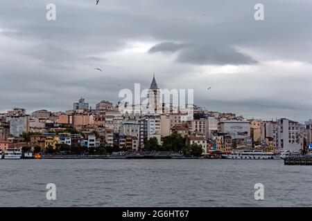 Tour Galata dans des bâtiments résidentiels de la vieille ville. Vue sur la côte de Karakoy depuis Bosporus. Mer et Corne d'Or par une journée nuageux. Banque D'Images