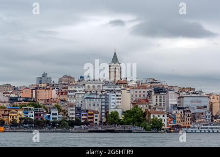 Tour Galata dans des bâtiments résidentiels de la vieille ville. Vue sur la côte de Karakoy depuis Bosporus. Mer et Corne d'Or par une journée nuageux. Banque D'Images