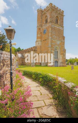 La tour et le chantier naval de l'église Saint-Nicolas dans le charmant et pittoresque village anglais d'Abbotsbury, Dorset, Angleterre, Royaume-Uni, par une belle journée d'été. Banque D'Images