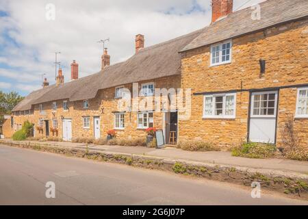 Cottages traditionnels en pierre à toit de chaume dans le charmant village anglais pittoresque d'Abbotsbury, Dorset, Angleterre, Royaume-Uni, en été. Banque D'Images