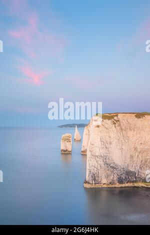Coucher de soleil ou lever de soleil coloré et idyllique sur le paysage marin des falaises de craie blanche et des piles de mer d'Old Harry Rocks sur la côte jurassique à l' Banque D'Images