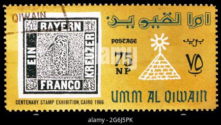 MOSCOU, RUSSIE - 21 MARS 2020 : timbre-poste imprimé en Umm Al Quwain montre le timbre de Bavière et le filigrane d'Égypte, exposition internationale du timbre Banque D'Images
