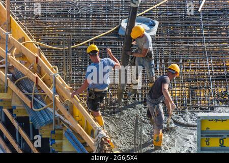 Wien, Vienne: Travaux de bétonnage sur le chantier de construction, ouvrier, installation de béton prêt à l'emploi à l'aide d'une pompe à béton en 22. Donaustadt, Wien, Mühlheim Banque D'Images