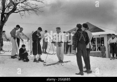 Skieurs pendant midi à l'extérieur de la maison de péage au pied du mont Mansfield, Smugglers Notch. Près de Stowe, Vermont, vers 1940. Pris en 1940, mais le gars au milieu de la photo semble qu'il vérifie son téléphone cellulaire Banque D'Images