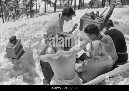 Les skieurs se détendent au soleil pendant midi à l'extérieur de la cabane du garde-forestier près du sommet du mont Mansfield, Smuggler's Notch, près de Stowe, Vermont, vers 1940 Banque D'Images