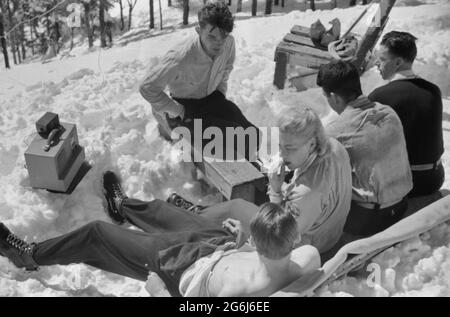 Les skieurs se détendent au soleil pendant midi à l'extérieur de la cabane du garde-forestier près du sommet du mont Mansfield, Smuggler's Notch, près de Stowe, Vermont, vers 1940 Banque D'Images