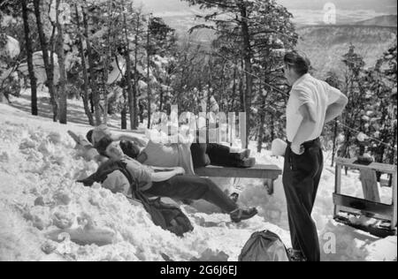 Les skieurs se détendent au soleil pendant midi à l'extérieur de la cabane du garde-forestier près du sommet du mont Mansfield, Smuggler's Notch, près de Stowe, Vermont, vers 1940 Banque D'Images