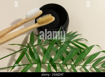 Un ensemble de brosses à dents écologiques en bambou et de poudre noire sur fond beige pastel. Un style de vie durable sans gaspillage. Concept sans plastique Banque D'Images