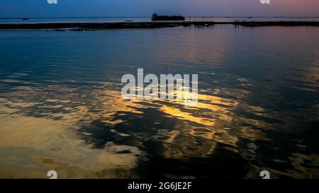 Belle vue sur le coucher du soleil sur la rive de la rivière. L'ombre du soleil sur l'eau de la rivière a créé un effet agréable par la suite. Banque D'Images