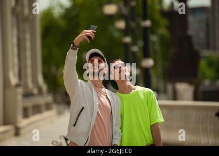 Deux beaux amis masculins posent pour les selfies qu'ils prennent Banque D'Images