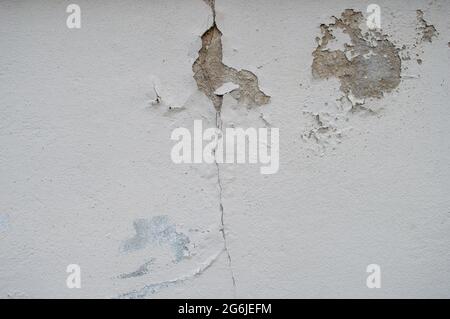 mur de maison fissuré affecté par les pluies et les tremblements de terre. ancien mur de maison blanc de fissure. Vieux mur d'un bâtiment ou d'une maison avec des fissures. Plancher de ciment Banque D'Images