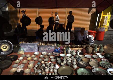 Un vendeur de porcelaine, de gongs et d'antiquités pendant le marché du dimanche de Gaya sur la rue Gaya, Kota Kinabalu, Sabah, Malaisie. Banque D'Images