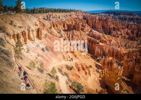 Bryce Canyon avec des formations rocheuses rouges de hoodoo vues d'en haut avec des randonneurs errant autour du fond Banque D'Images