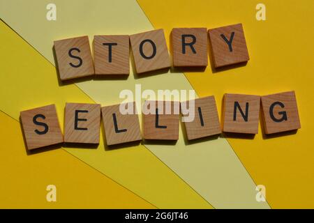 Story Sellling, mots en lettres de l'alphabet en bois isolées sur fond jaune Banque D'Images