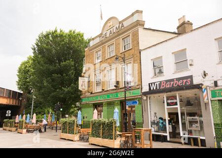 Les gens qui apprécient une pinte tranquille et socialement distancée devant Alma Tavern, Old York Road, Wandsworth, Londres SW18, Royaume-Uni Banque D'Images