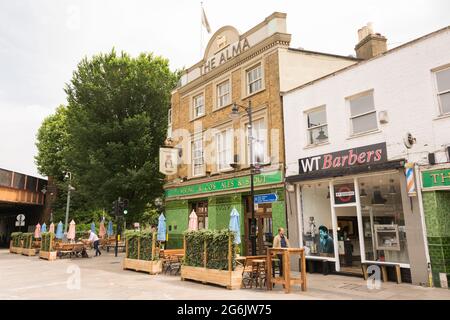 Les gens qui apprécient une pinte tranquille et socialement distancée devant Alma Tavern, Old York Road, Wandsworth, Londres SW18, Royaume-Uni Banque D'Images