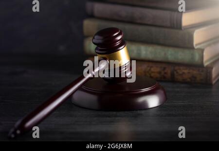 Juges en bois Gavel sur un bureau avec des livres en arrière-plan Banque D'Images