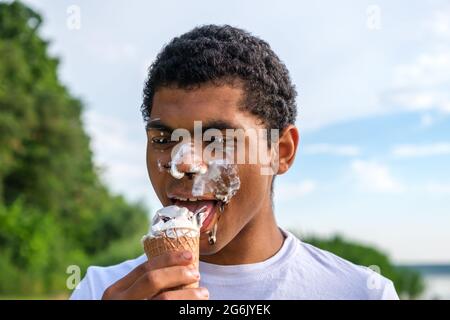 Homme avec de la glace fondue sur son visage à l'extérieur en été Banque D'Images