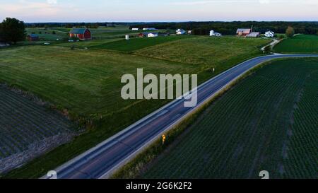 Vue aérienne de la ferme amish et des champs fertiles de maïs, de foin de luzerne et de pâturages parsemés de bétail, courbe dans la route de campagne, Hillsboro, Wisconsin, États-Unis Banque D'Images