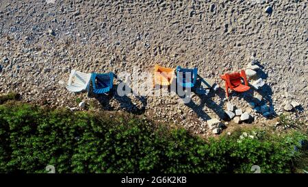 Vue aérienne d'un groupe de chaises adirondack colorées sur une plage au coucher du soleil dans le comté de Door, Egg Harbor, Wisconsin, États-Unis Banque D'Images