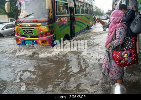 Un bus traversant de l'eau de pluie sur une route inondée pendant la pluie de mousson. Quelques heures de pluie créent de l'engorgement dans les rues car le système d'égouts et de drains n'est pas nettoyé et entretenu correctement. Dhaka, Bangladesh. Banque D'Images