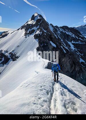 l'alpiniste bénéficie d'une vue sur la montagne clariden avec la crête de glace. Ski sur le dos, belle vue sur la montagne Banque D'Images