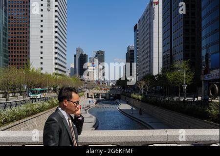 29.04.2013, Séoul, Corée du Sud, Asie - UN homme parle au téléphone dans le centre-ville de la capitale sud-coréenne avec le Cheonggyecheon Stream. Banque D'Images