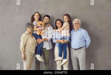 Portrait en studio de maman, papa, enfants et grands-parents heureux debout ensemble et souriant Banque D'Images