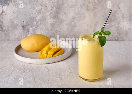 Lassi de mangue, smoothies ou milkshake sur fond clair. Boisson traditionnelle indienne avec yaourt, épices, fruits et glace. Étanche parfaitement la soif Banque D'Images