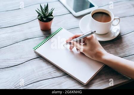 Femme écrivant à la main sur ordinateur portable.vue de dessus du lieu de travail pour femme. Banque D'Images