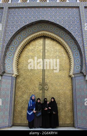 Femmes musulmanes debout devant une grande porte en laiton au Palais Royale de Fès, au Maroc Banque D'Images