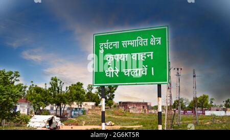 Panneau vert avec texte blanc attrayant le long de la route latérale. Langage écrit en blanc avec fond vert. Banque D'Images