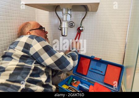 Bricolage comme plombier à assembler un nouveau lavabo dans la salle de bains Banque D'Images