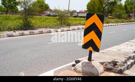 07 juillet 2021- Reengus, Sikar, Inde. Panneau de signalisation jaune et noir réel pour indiquer l'autonomie de la route. Concept de signalisation et de symboles de sécurité routière. Banque D'Images