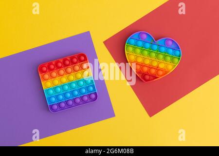 Jeux sensoriels anti-stress pop IT colorés pour les enfants sur fond multicolore. Banque D'Images