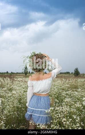 femme méconnue dans un domaine de pâquerettes blanches sauvages dans une vallée pittoresque. Bonjour été. Digital Detox, week-end dans la nature, à la recherche de l'inspiration, fr Banque D'Images